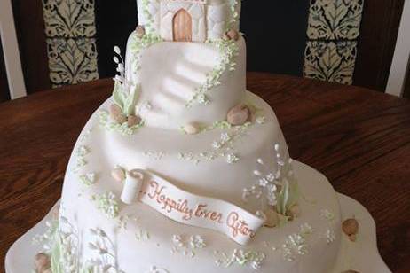 A sculpted castle cake with lily of the valley accents.