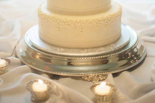 A three tier buttercream cake with cascading pearls.