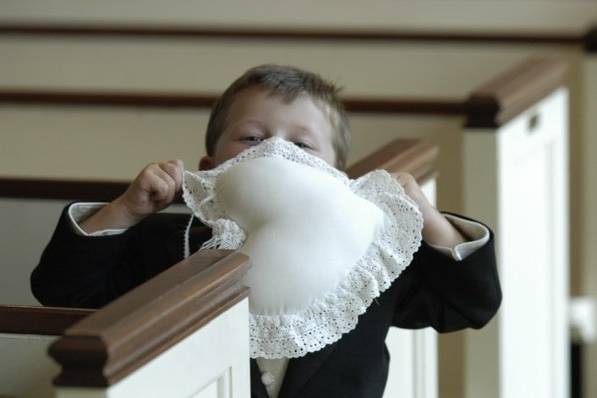 You can dress them up in little tuxedos but they are still kids. After completing his duty as a ring bearer this little guy tried to contain himself in one of the churches pews but the sillies took over.