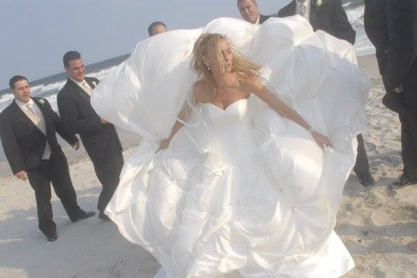 The unpredictability of day with so many factors makes for the best photos. Here a bride gives an unintentional show to her groomsmen when a strong wind blows up her gown.