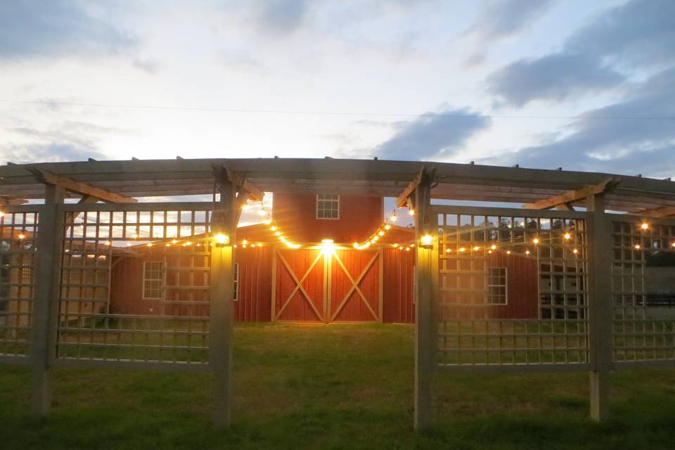 The area directly in front of the barn (east side) is enclosed by a semi-circular pergola with string lights from the barn to the pergola. Gorgeous area for a small wedding, with room to set up for 100-125 or so. Also would be nice for an evening party, etc.