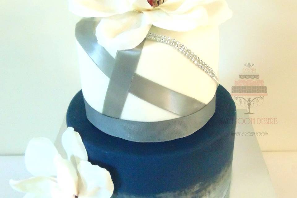 2 Tier (6in and 8in) Cream, Navy Blue and Silver Wedding Cake. Bottom tier was brushed in sliver luster dust, top tier w/ silver ribbon and rhinestones, and faux Magnolia flowers.