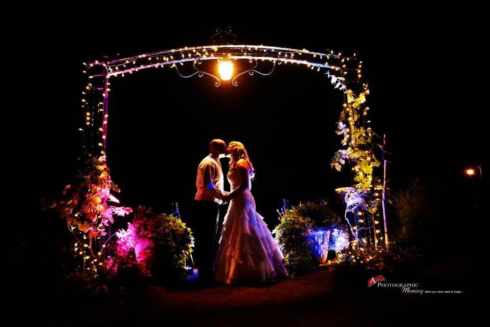 Evening kiss under the lighted arch