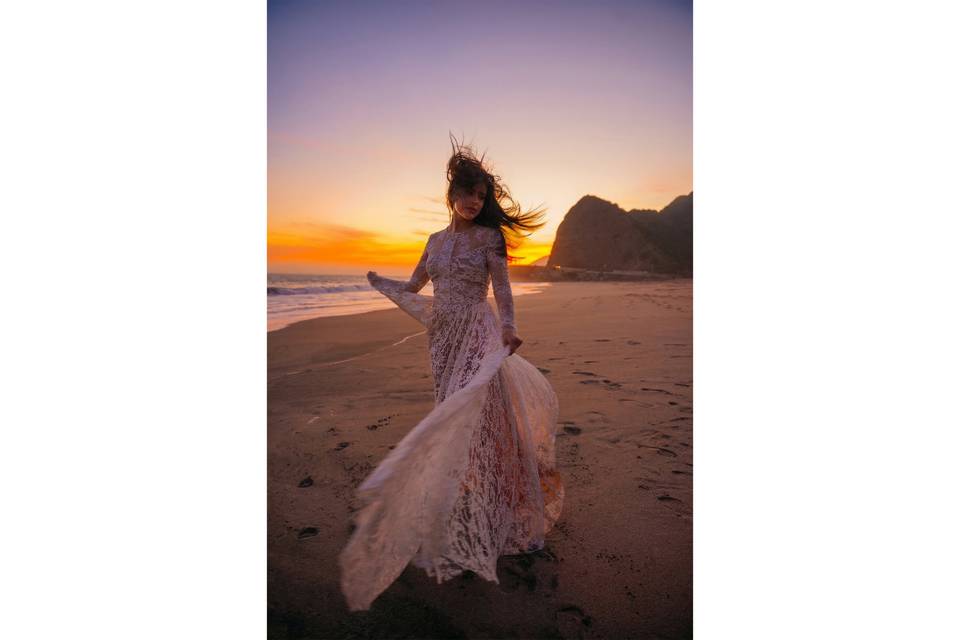 Bride dancing on beach sunset