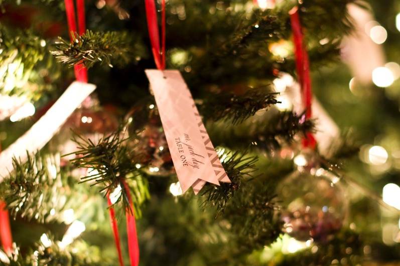 Mix of Letterpress, and Screen Printing. Glitter, Satin, Metallic and Felt Details.Escort Cards hanging on a pine tree.