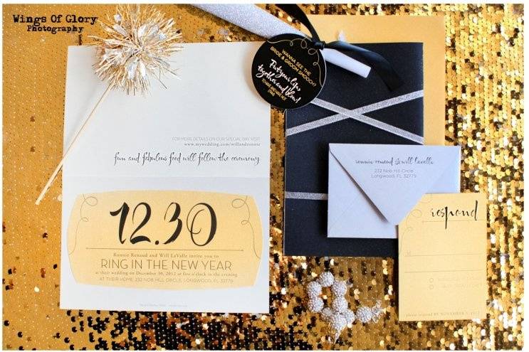 Old Hollywood Glamour New Year's Eve Wedding. Black Linen accented with gold glitter, Die Cut Glitter Numbers and words on various pieces, Silver, Gold and Champagne  Metallic Paper, Sparklers, Noise Makers and Raffle Tickets. Quotes from Old Hollywood movies adorned various signage, tags, etc. Invitations Round 2-- After the mailing, When the bride underestimated her guest list, and we were out of die cut glitter dates, we were able to make a version 2, without the glitter die cut date to save the day!