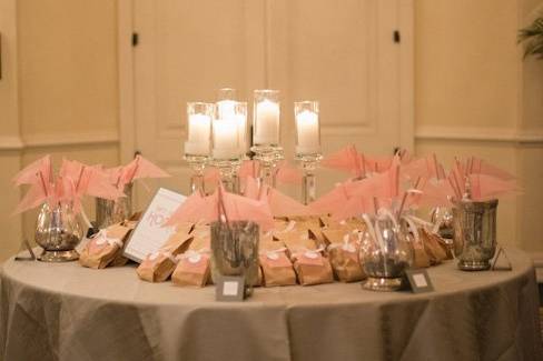 Escort card/favor table. Because the bride and groom are both avid Soccer Players, we created Dusty Rose Vellum Pendant escort cards. Center of the table filled with 