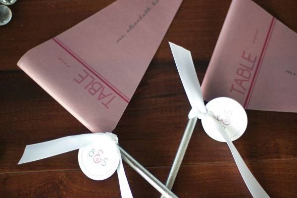Escort card/favor table. Because the bride and groom are both avid Soccer Players, we created Dusty Rose Vellum Pendant escort cards.  2ucollection.com