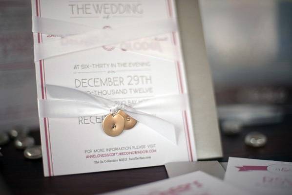 Super thick 130# felt paper with 2 color letterpress bound together with a white satin ribbon and silver flat charms with their initials punched into them. We developed a monogram for the bride and groom, that you will see throughout the whole event! 2ucollection.com