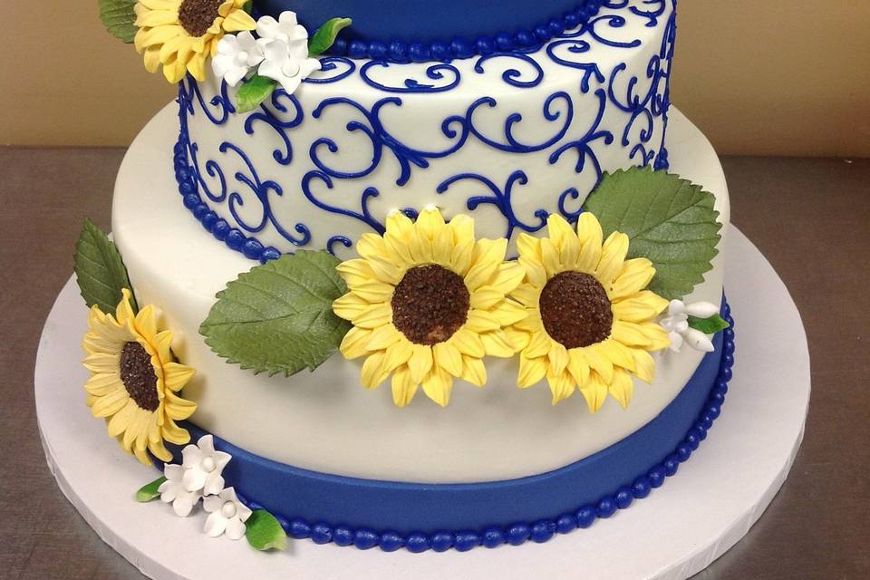 3-tier wedding cake with sunflowers and blue detailing