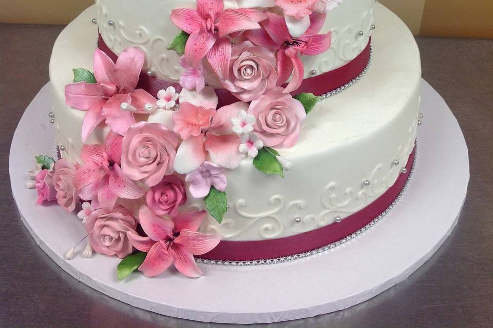 Pink flowers and lining on a 3-tier wedding cake