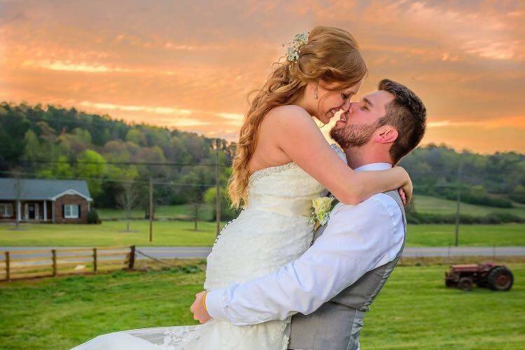 Newlyweds kiss by the sunset