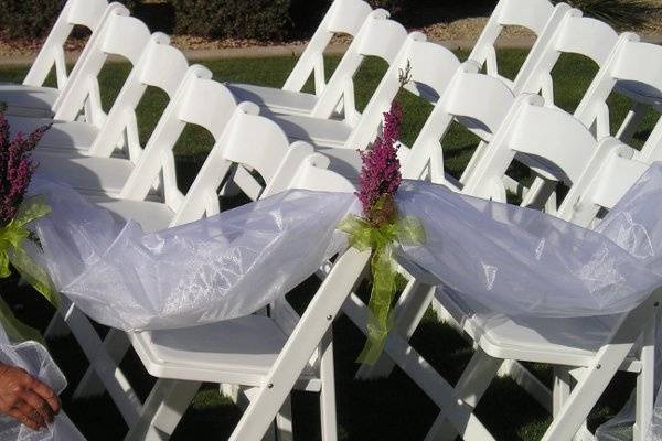 Organza aisle markers with flowers to match wedding colors.