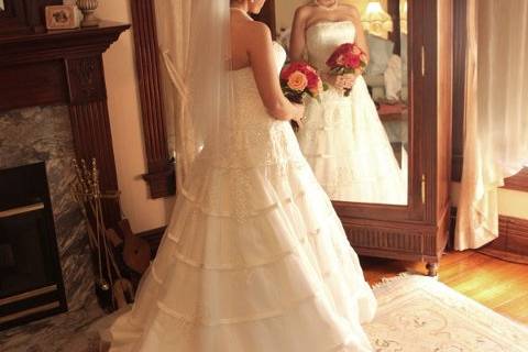 Bride reflecting in French armoire mirror in honeymoon suite. One of St. Louis' most romantic wedding venues. Photo courtesy Gravemann Photography East Alton, IL 62024.