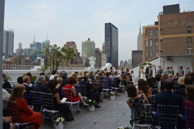 Our couple exchanging their vows on the roof of Studio 450 in Manhattan, NY.  The New Yorker Hotel and Empire State Building for a backdrop.  We provided PA and music for their ceremony.  Very romantic!