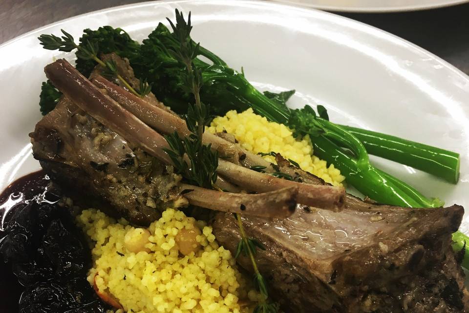 Lamb chops over couscous with minted michigan cherry sauce and broccolini