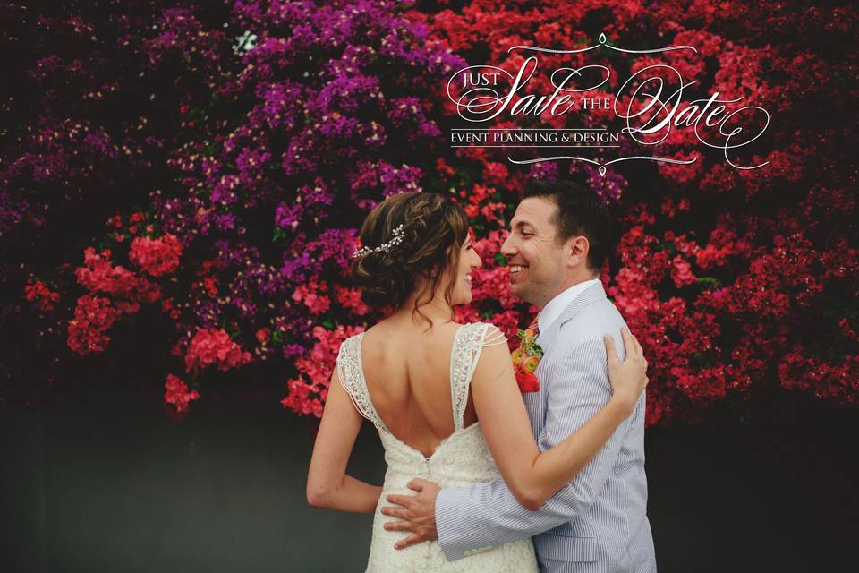 Newlyweds with flower backdrop