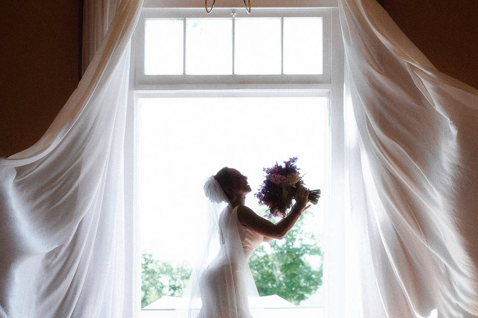 Bridal portrait by curtains