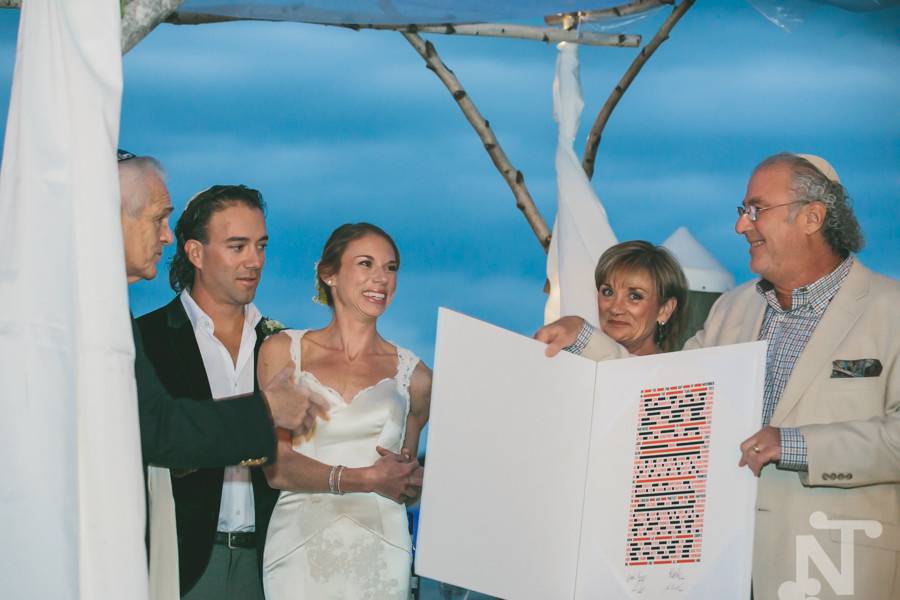 Parents displaying the ketubah during wedding ceremony