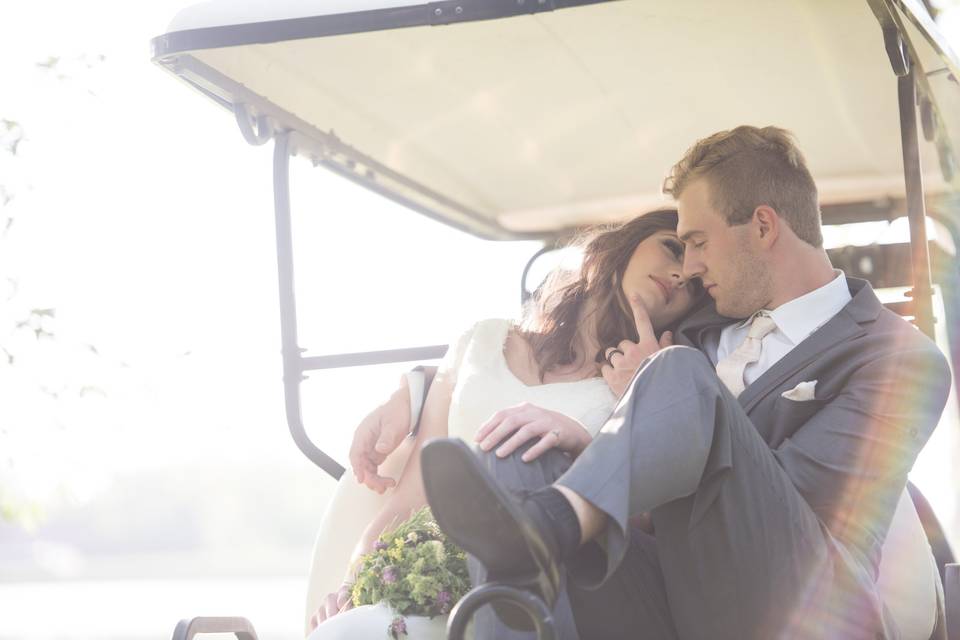 Bride and groom on a golf ca