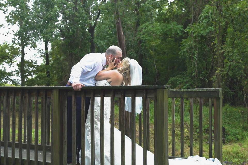 Bride and Groom kiss at bridge