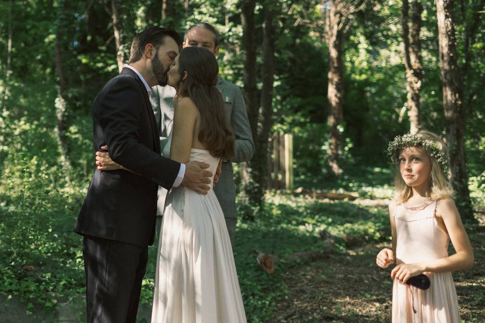 Flower girl smirks at the kiss