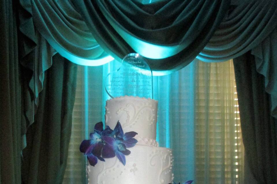White wedding cake with blue and purple flowers