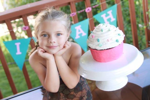 Girl with a big cupcake on her side