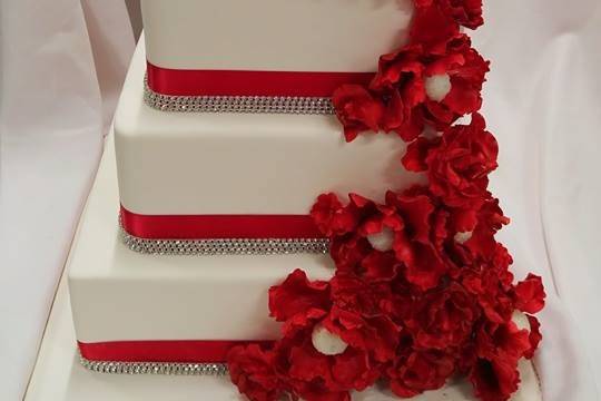Beautiful red roses cascade on this delightful wedding cake.