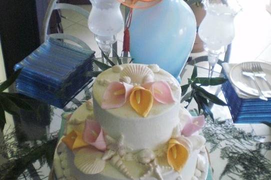 2-tier round cakes finished in white buttercream.  Hand made edible fondant calla lillies and sea-shells complete this tropical beach themed wedding cake.