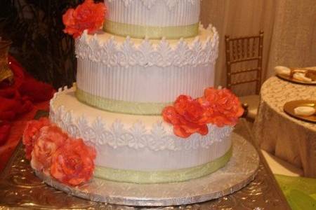 3-tier fondant covered round cakes with lace trim and coral roses.  A through back to the older style wedding cake.