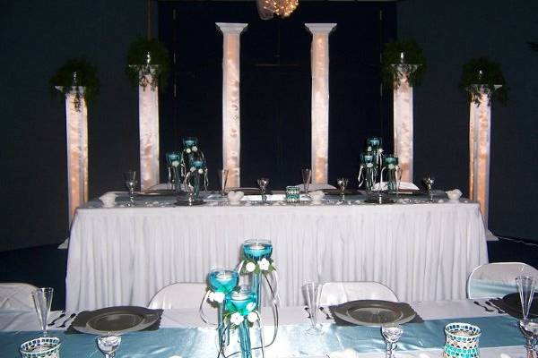 Head table set-up with stagered heights. Lighted column back drop.