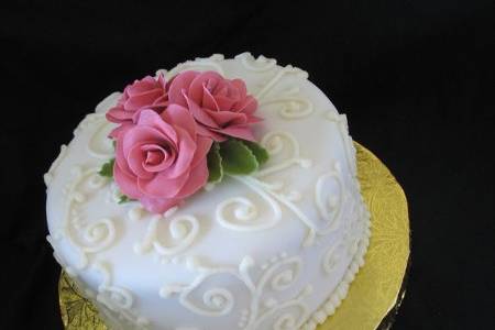Fondant covered cake with handmade roses and piping
