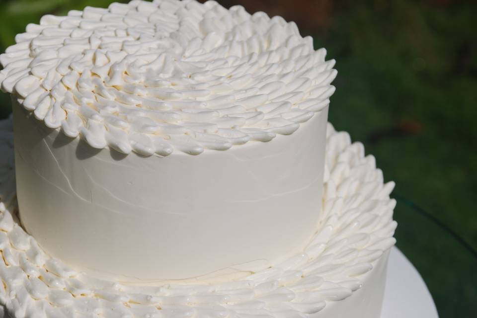 Chrysanthemum topped wedding cake with smooth finish sides.