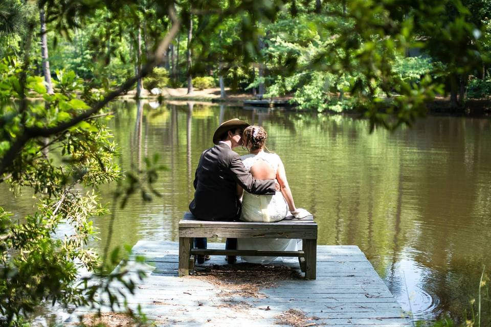 Groom and bride sitting by the lake