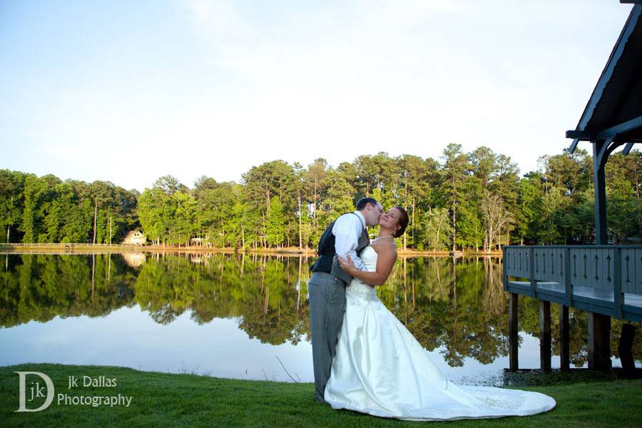 Groom kissing his bride by the lake