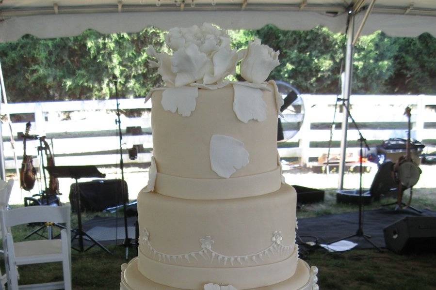 Handpainted Red sugarpaste roses, white stephanotis with silver accents and fondant ribbon.