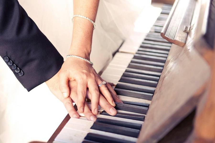 Couple holding hands by the piano
