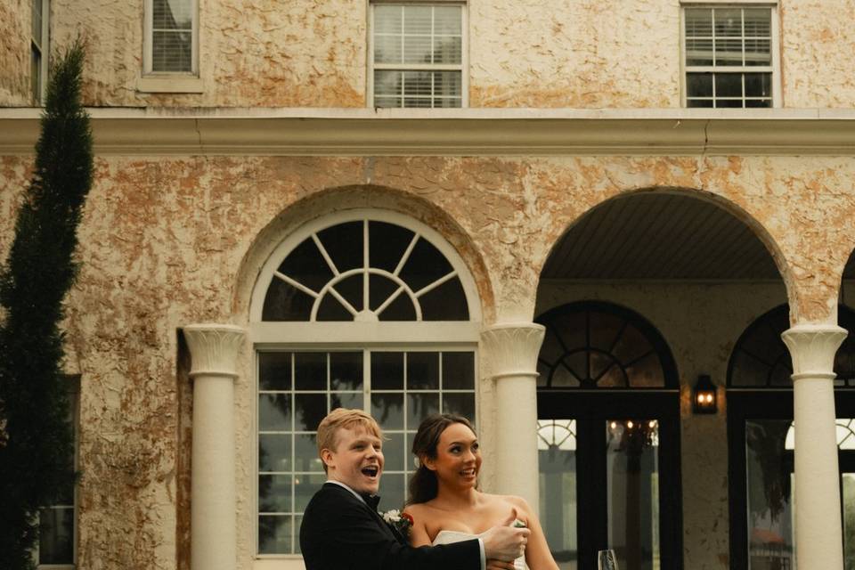 Bride and Groom pop champagne