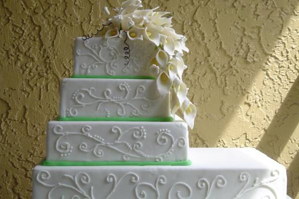 Hand crafted calla lily's cascade over this elegant fondant cake. Alternating tiers of vanilla cake with key lime filling and chocolate cake with fresh strawberry filling. A beautiful spring cake!