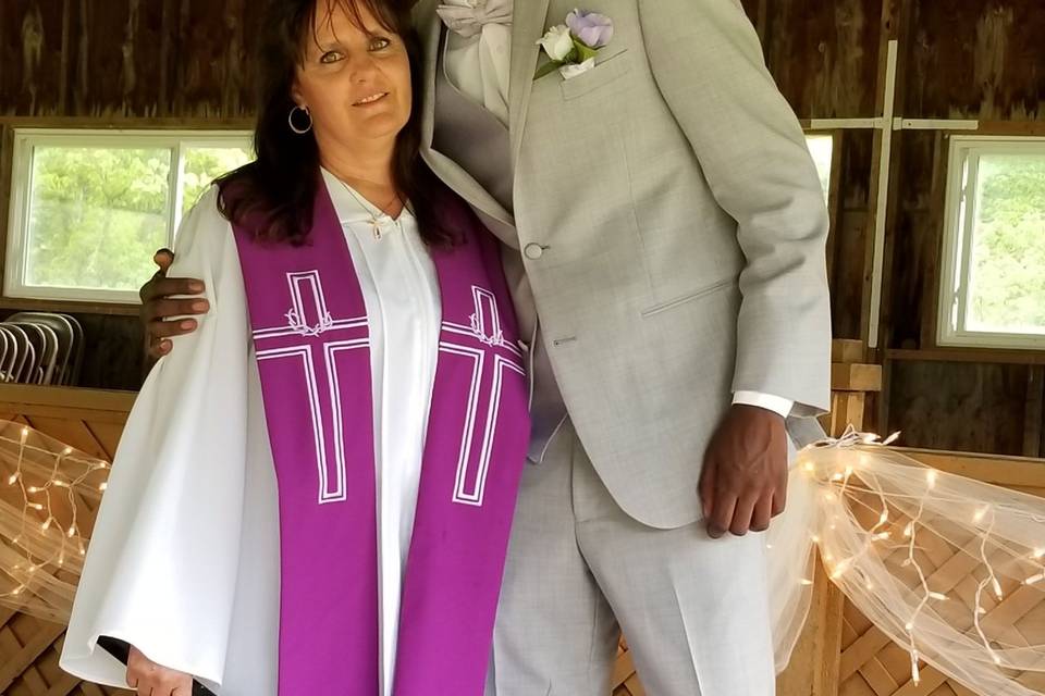 The groom posing with the officiant