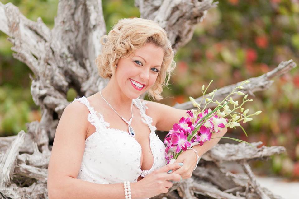bride poses at driftwood on Sanibel Island sunrise wedding