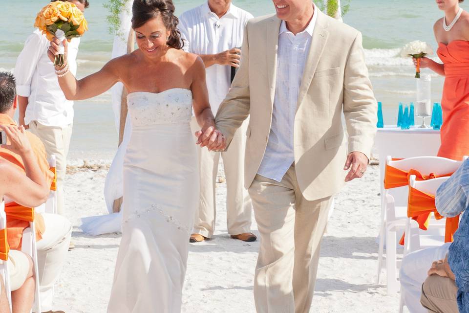 Happy couple leave their beach wedding ceremony at the Casa Ybel Resort on Sanibel Island