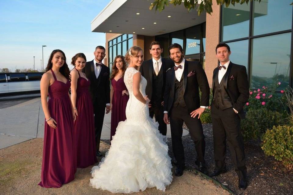 Newlyweds, bridesmaids, and groomsmen outside venue