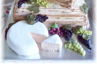 wine bottle cake on crate with brie cheese cake and candy grapes