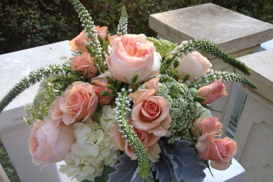 This cocktail vase features David Austin peach roses paired perfectly with white Hydrangeas and Dusty Miller. The result is soft and romantic.