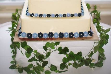 Hand-pressed flowers trim the tiers of this butter cream frosted confection. The monogram is backed by chocolate.