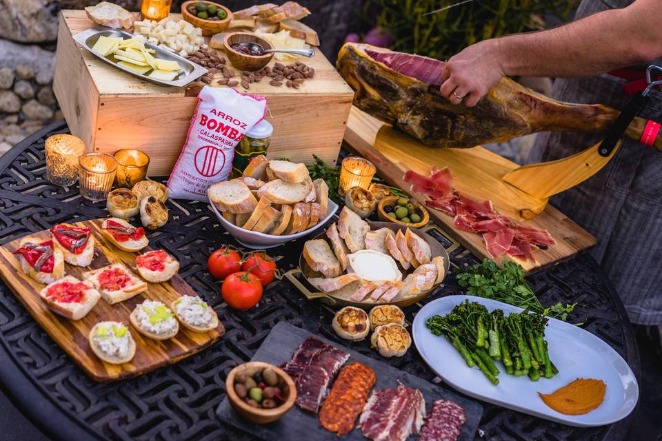Appetizer station for a tapas party in Highland Park, Los Angeles. A selection of Spanish cheeses, olives, grilled broccolini and romesco, cured meats, baked goat cheese with orange honey, roasted garlic and toasts (anchovy and piquillo, pan con tomate and smoked trout rillette). And (of course) a lovely leg of jamón.