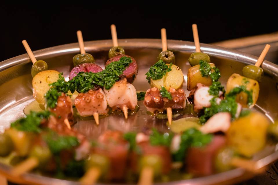 Grilled octopus skewer with fingerling potato, olive topped with a salsa verde.