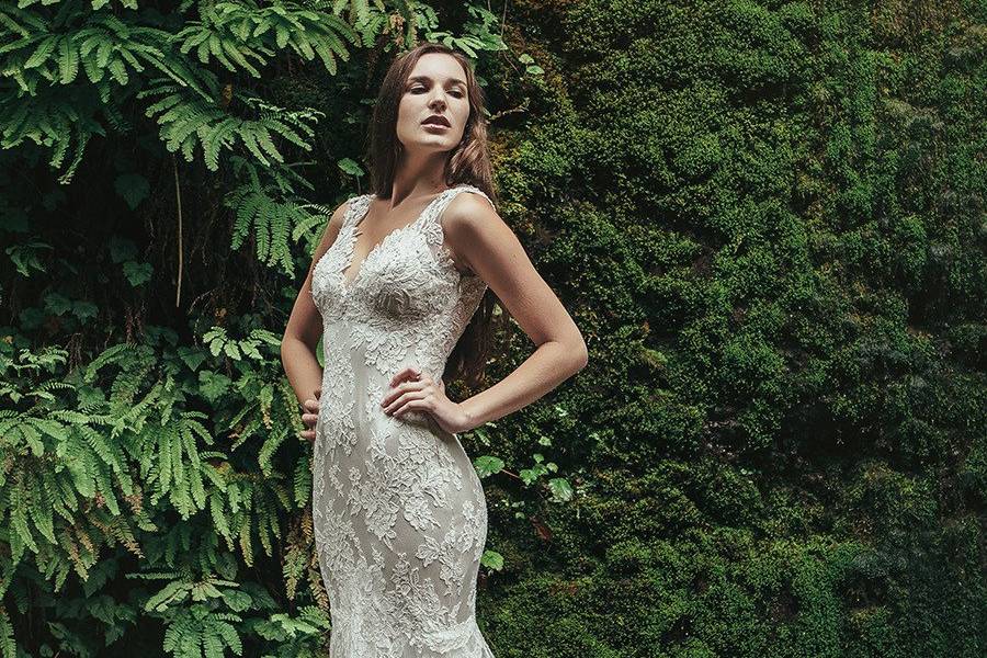 BristolIvory Alençon lace gown with a beaded lace illusion back. Mink crepe back satin provides a lightweight and slim fit, with a sheer tulle circle skirt with horsehair and large scallop for a dramatic skirt without the weight.